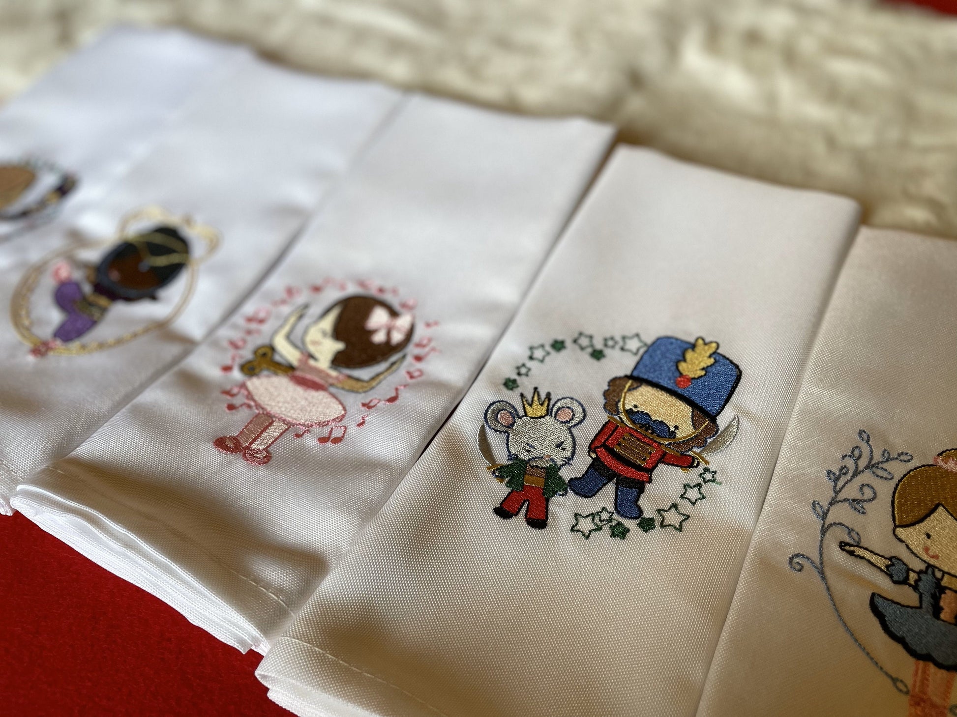 Embroidered fabric squares with cartoon characters on a textured surface
